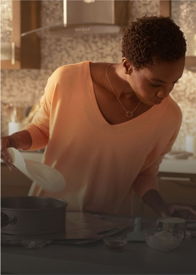 A woman prepares a meal in a kitchen outfitted with Whirlpool® appliances