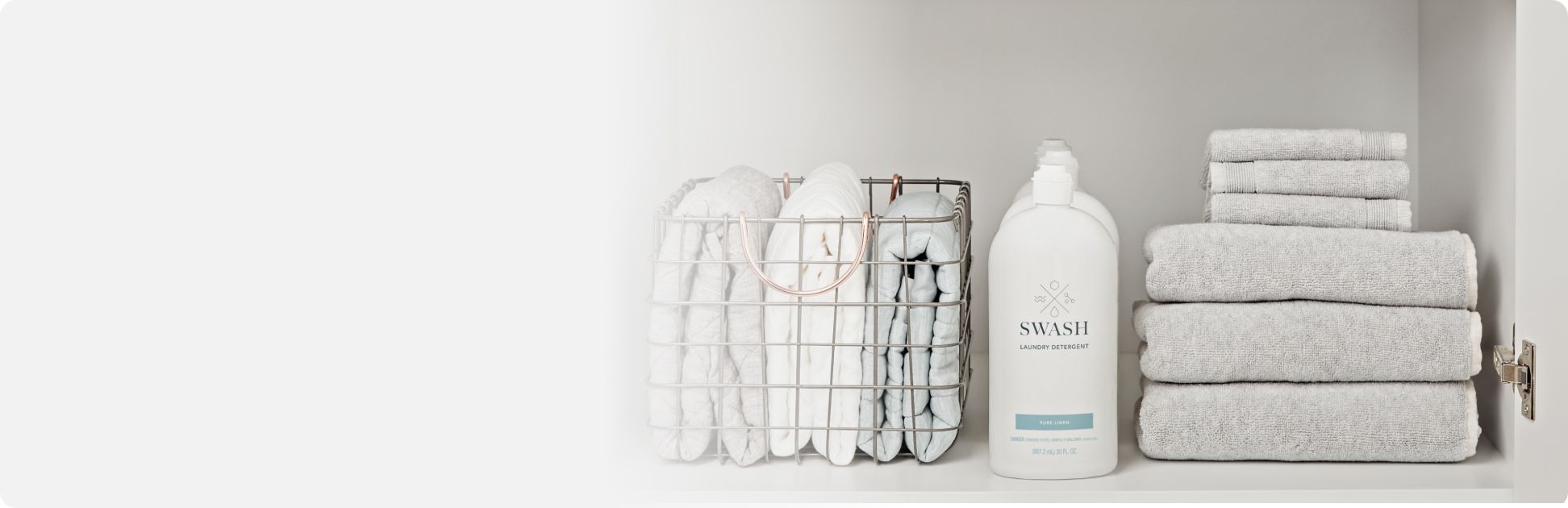 A bottle of Swash® Laundry Detergent next to folded towels.