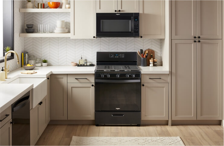 A Whirlpool® Freestanding Range and Over-the-Range Microwave in a kitchen with light taupe cabinets