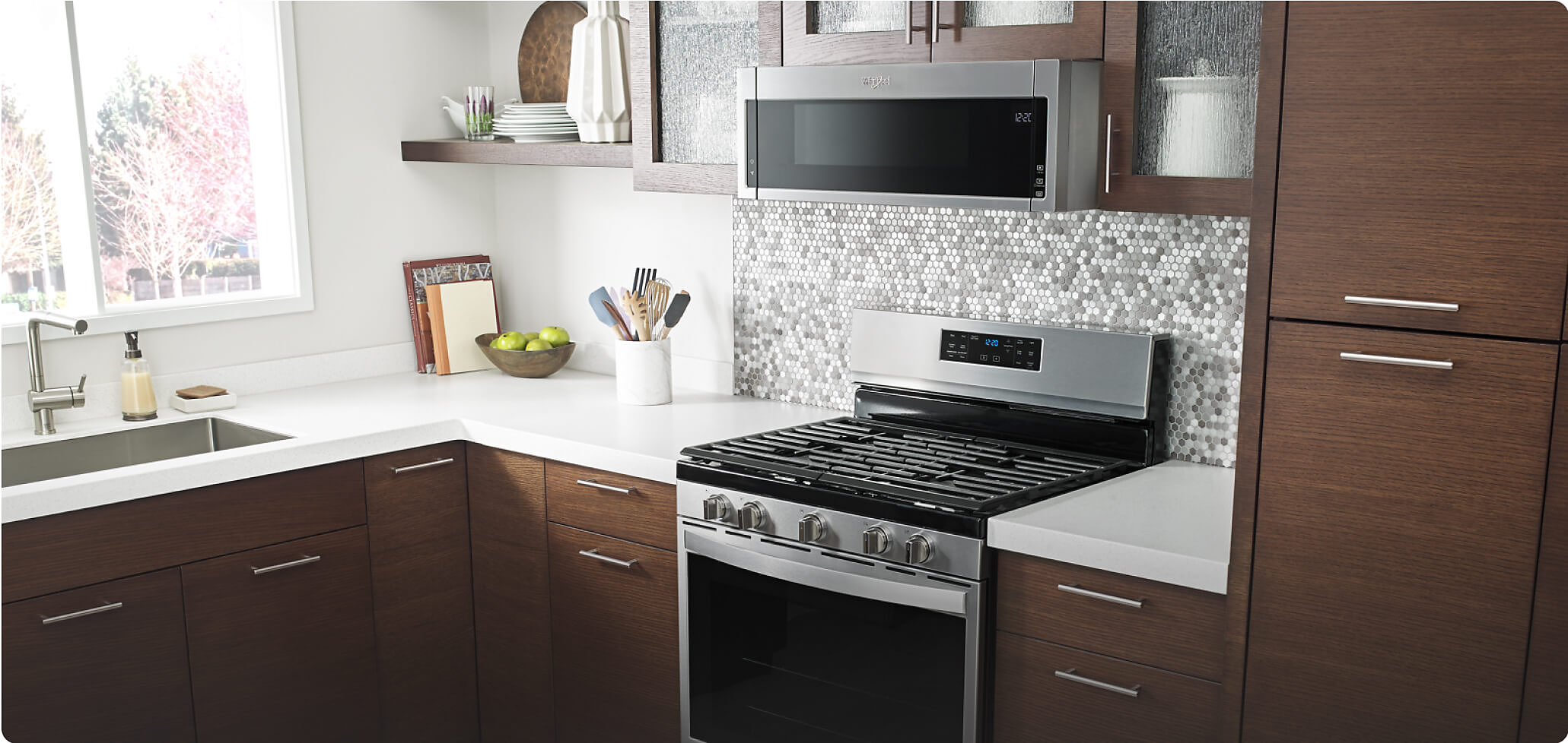 Whirlpool® Freestanding Gas Range and Low Profile Microwave Hood Combination in a kitchen with brown cabinets