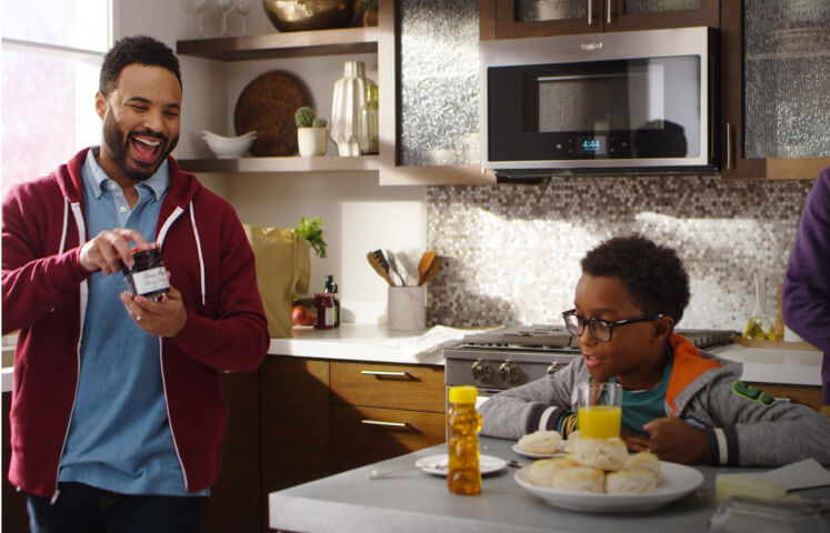 A multi-generational family eating biscuits in the kitchen, with the home heartbeat appliance blog logo