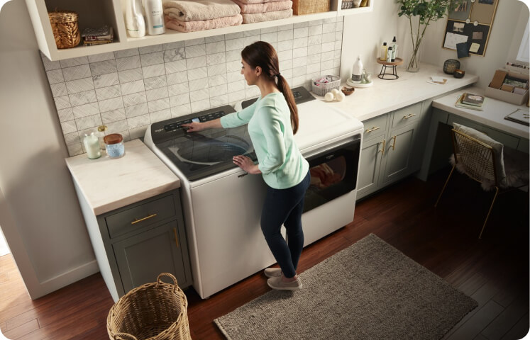 A person running a Whirlpool® Top Load Washing Machine