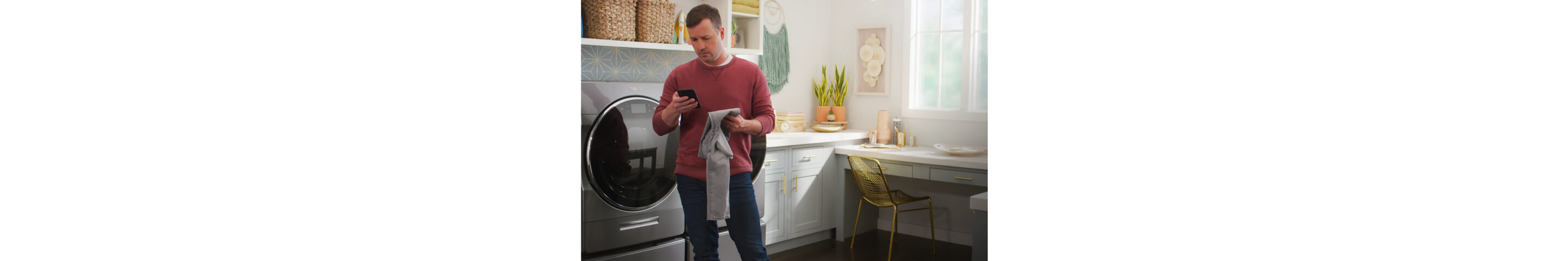 一名男子在洗衣房拿着智能手机，上面有家心跳博客的标志