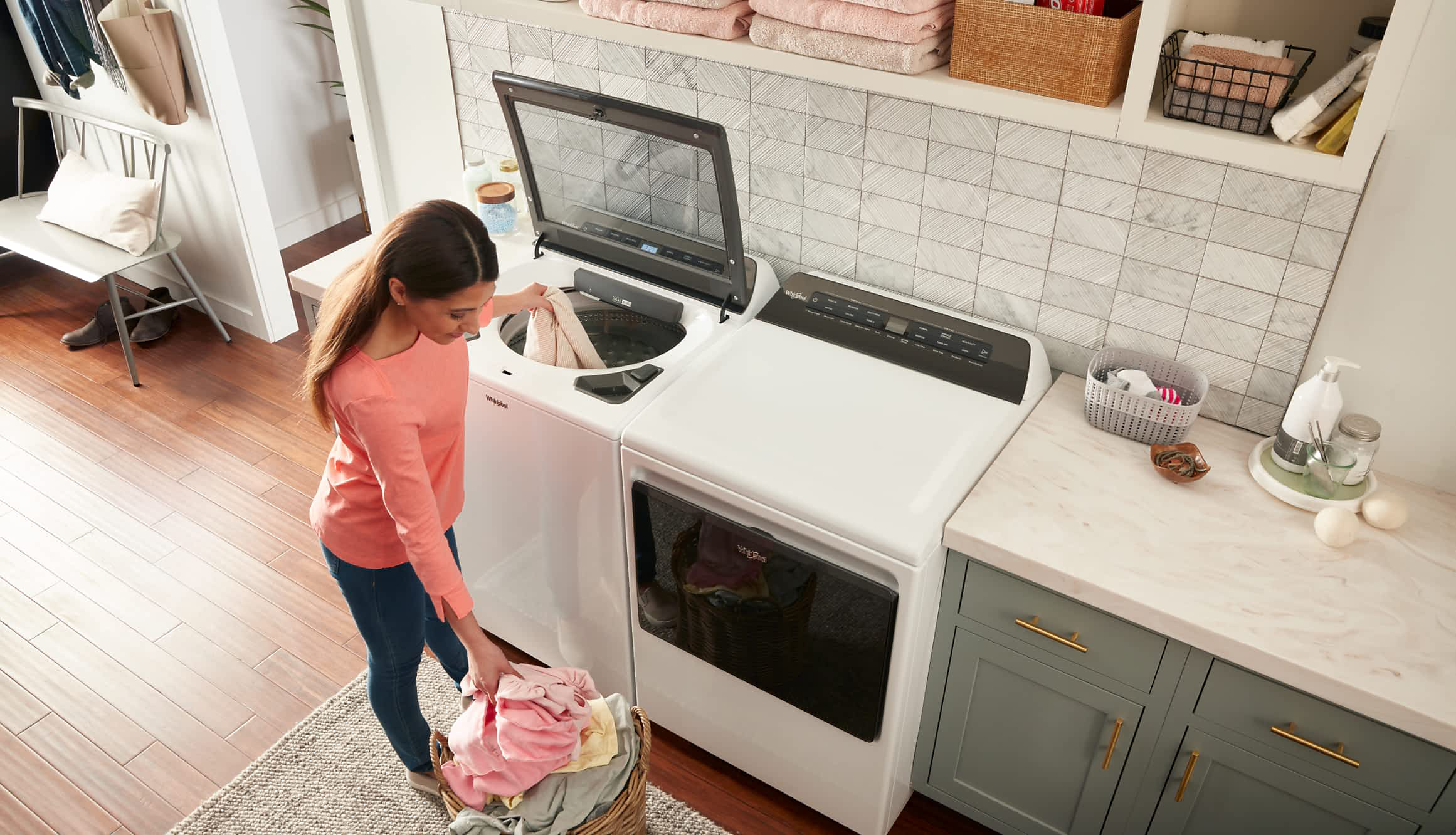 A person loads laundry into a Whirlpool® 2 in 1 Removable Agitator Washer