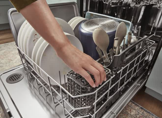 A hand picking up one section of the 3-Piece Silverware Basket in a dishwasher