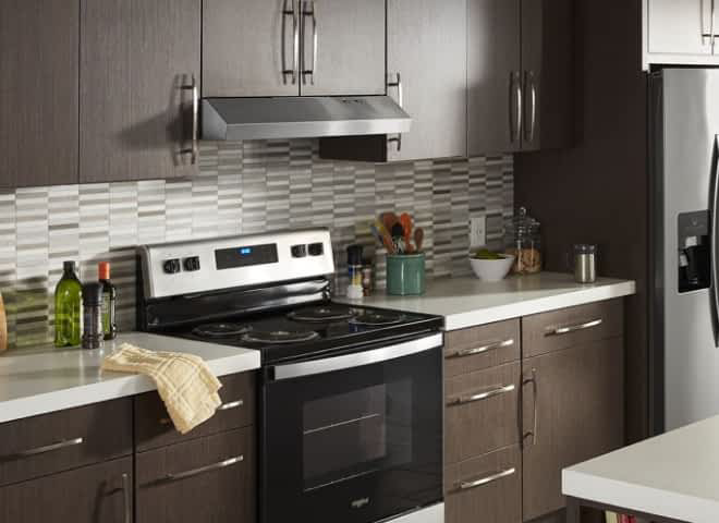 A Whirlpool® Undercabinet Hood in a kitchen with brown cabinets