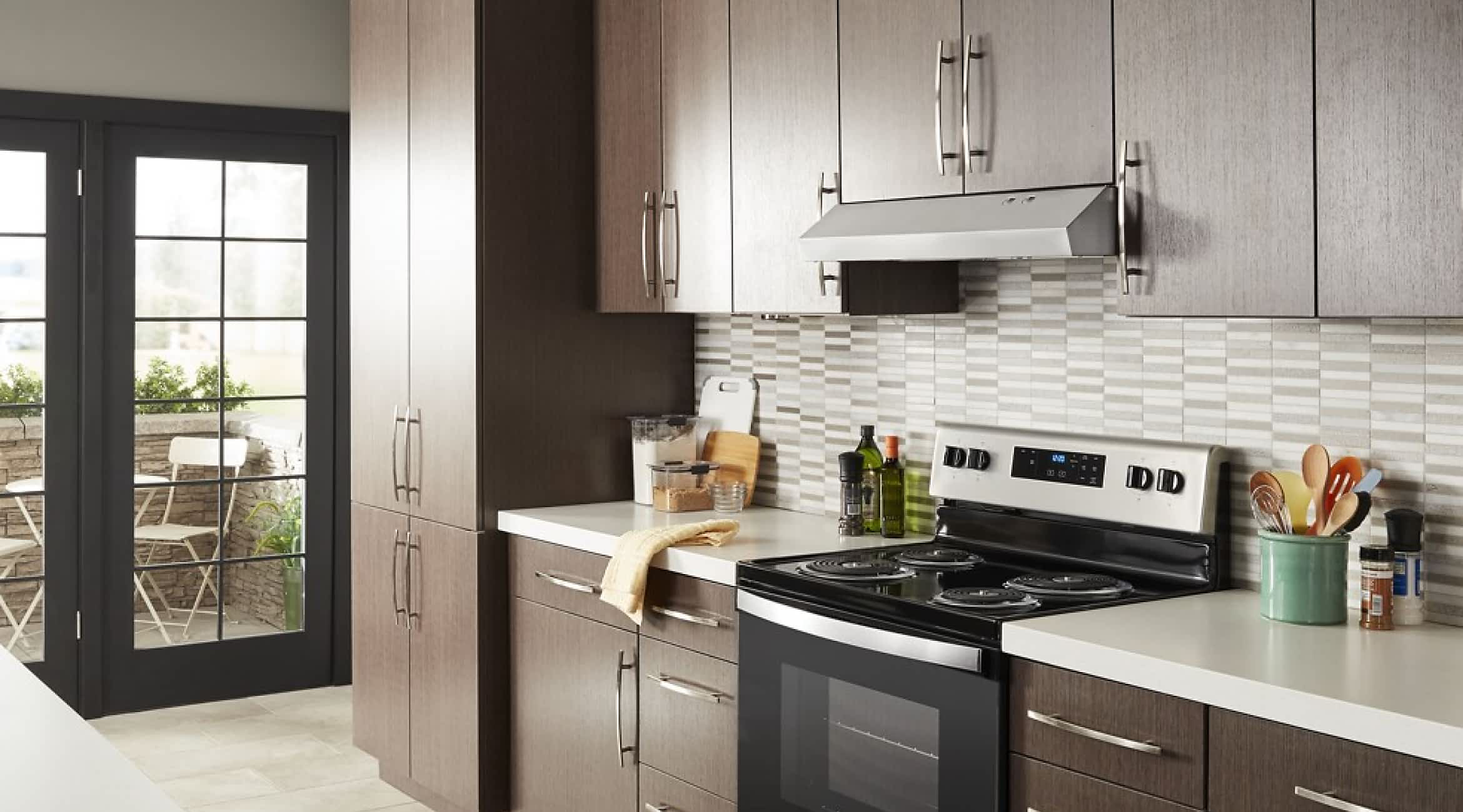 A Whirlpool® Undercabinet Hood in a kitchen with brown cabinets