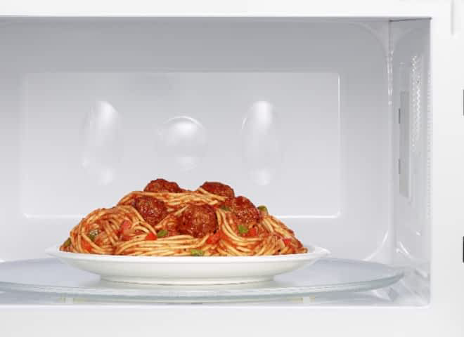 A plate of spaghetti sits inside of a Whirlpool® Microwave