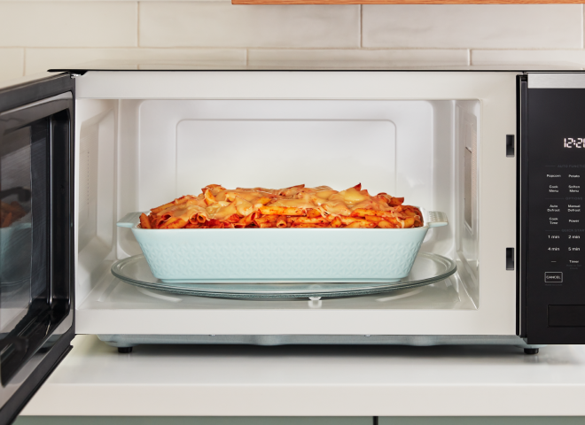 A casserole dish with baked ziti sits inside of a Whirlpool® Microwave
