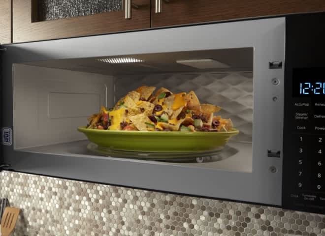 A large plate of food sits inside a Whirlpool® Microwave