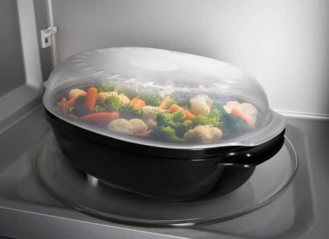 The inside of a microwave shows a bowl of food being steamed.