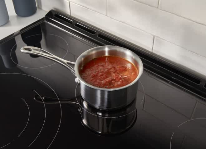 A pot rests on the cooktop of a Whirlpool® Electric Range