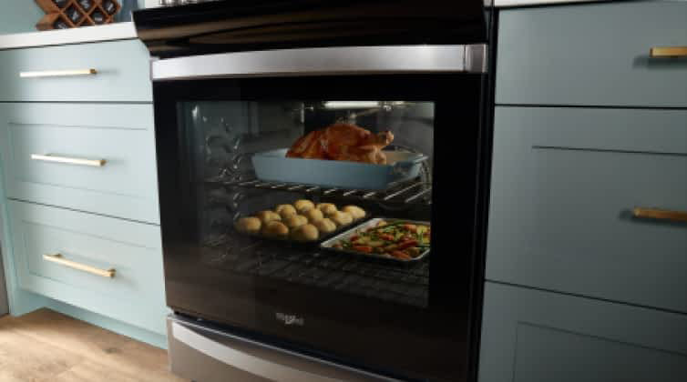 A Whirlpool® Range with multiple dishes cooking in the oven