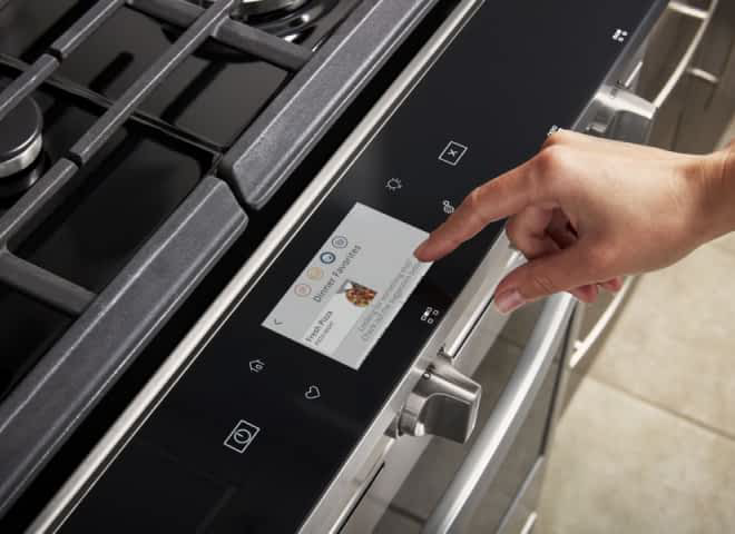 Hands operating a Whirlpool® Smart Range's Touchscreen