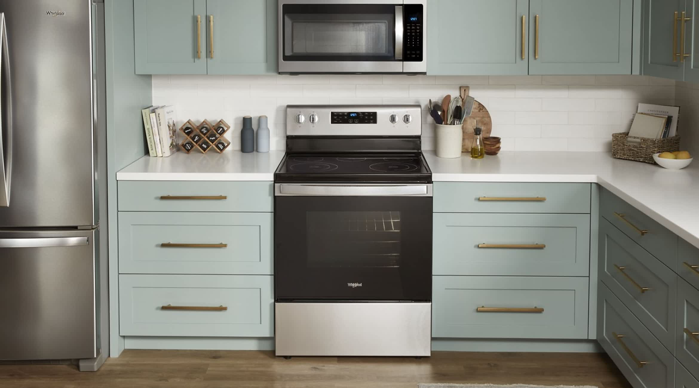 A Whirlpool® Standard Freestanding Range in a kitchen with green cabinets