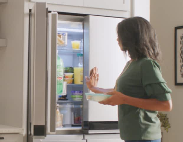 A woman opening a Whirlpool® Refrigerator