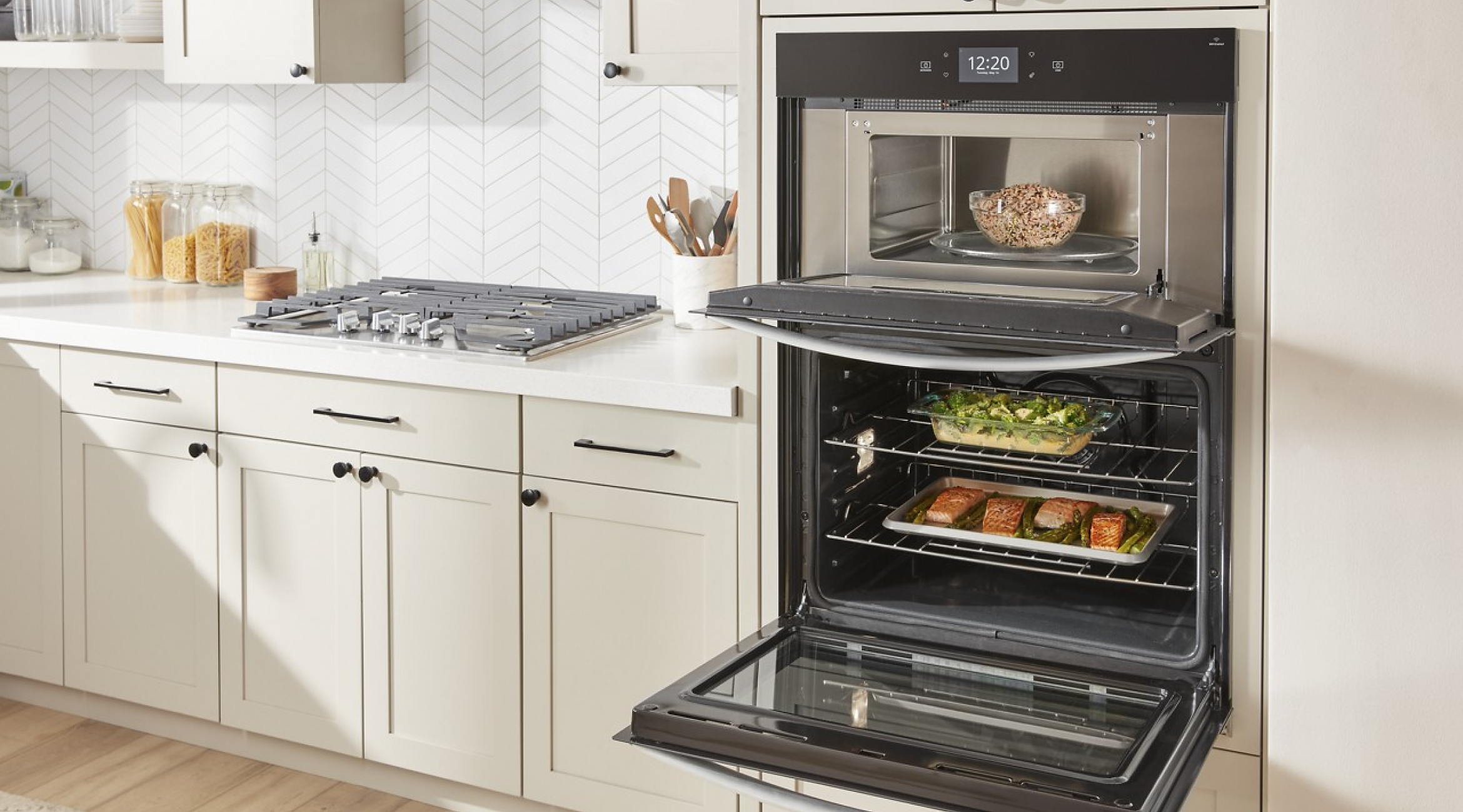 A Whirlpool® Premium Combination Wall Oven in a kitchen with the doors open, showing food inside the oven and microwave