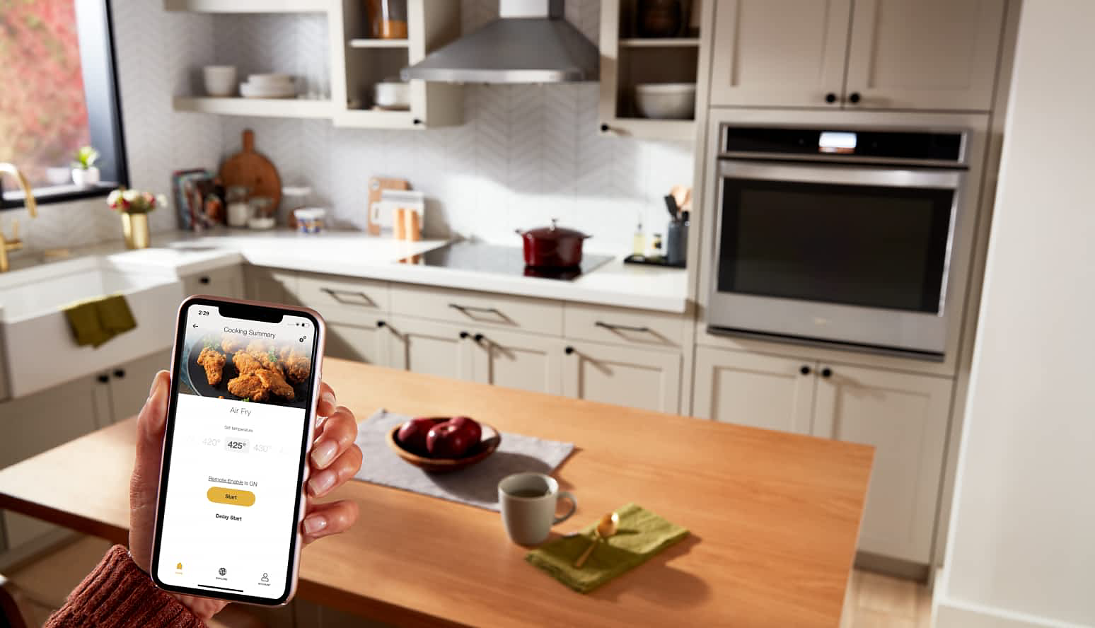 A person using the Whirlpool® App to set the temperature on a Whirlpool® Wall Oven