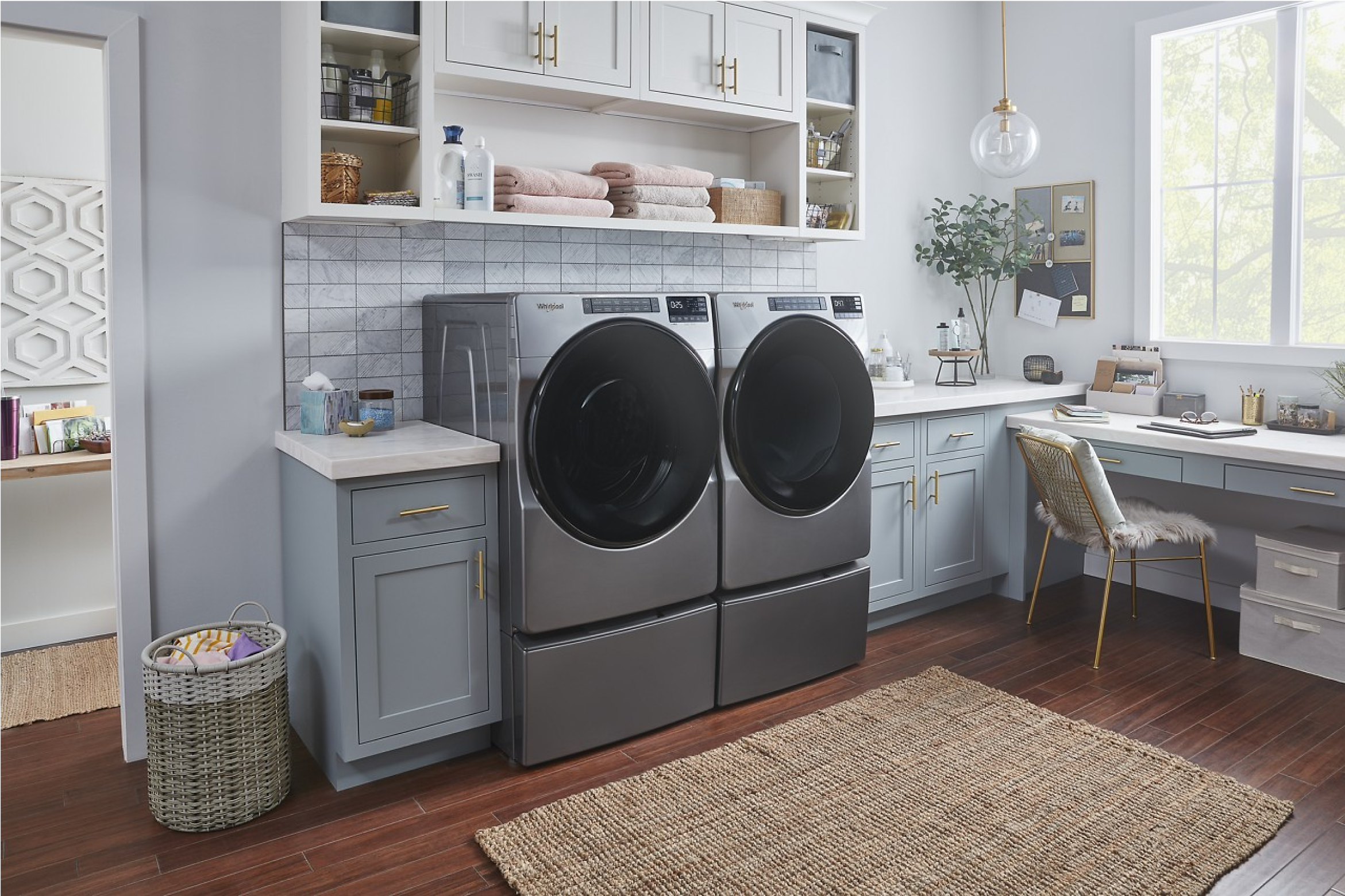 A Whirlpool® Front Load Washer & Dryer Set in laundry room with light cabinets