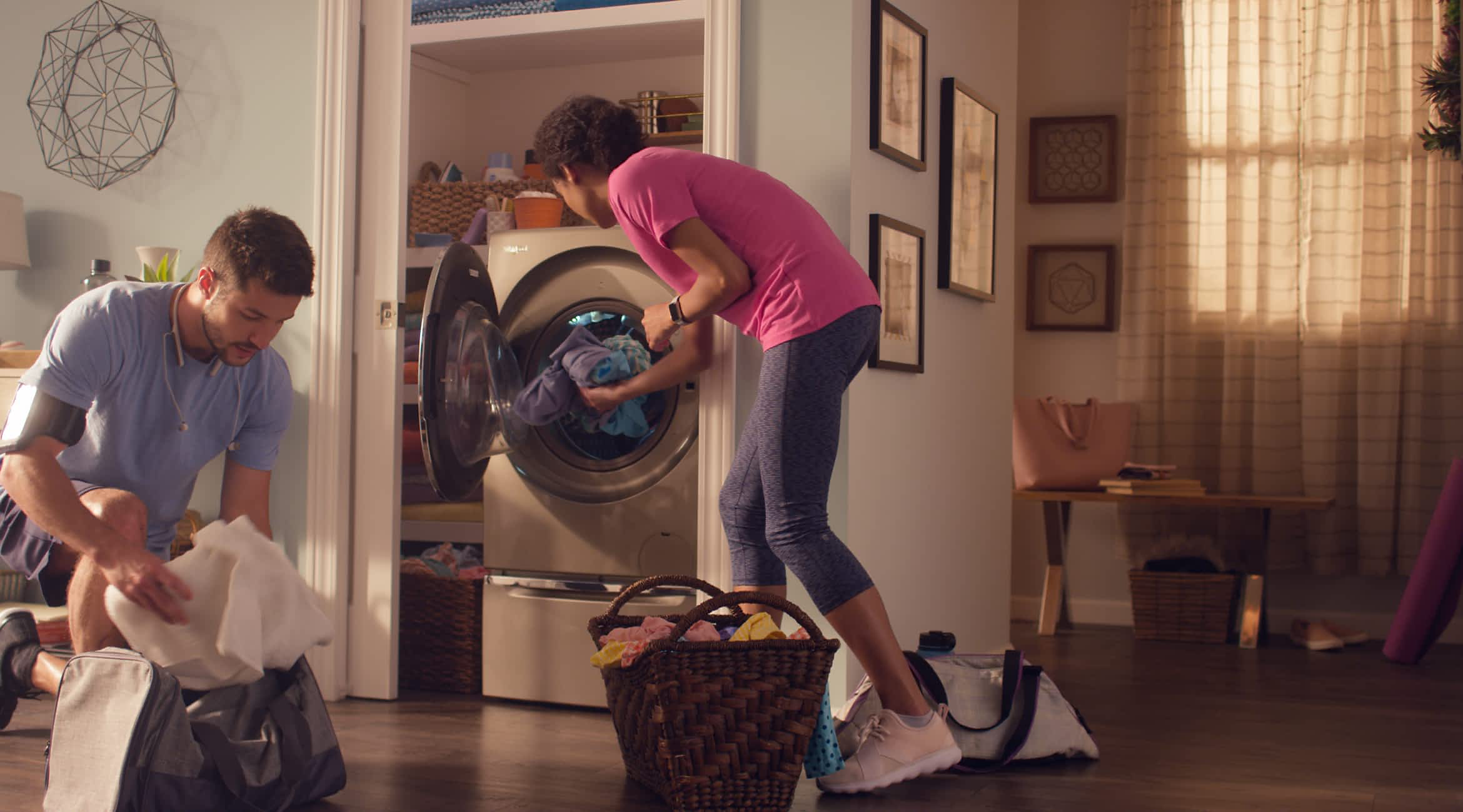 A couple sorting and loading laundry in a Whirlpool® All-In-One Washer & Dryer