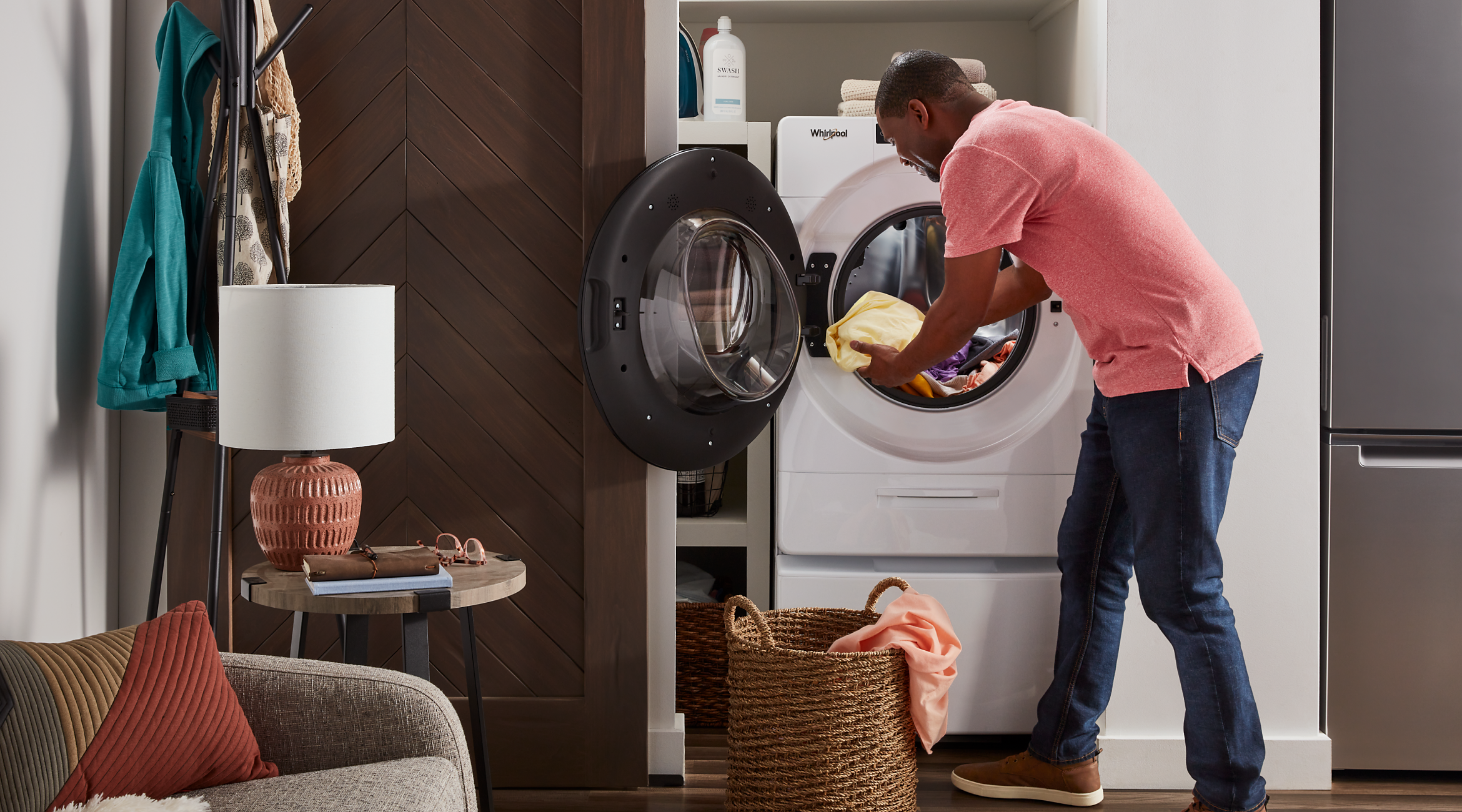 A person removing a dry load of laundry from a Whirlpool® All-In-One Washer & Dryer