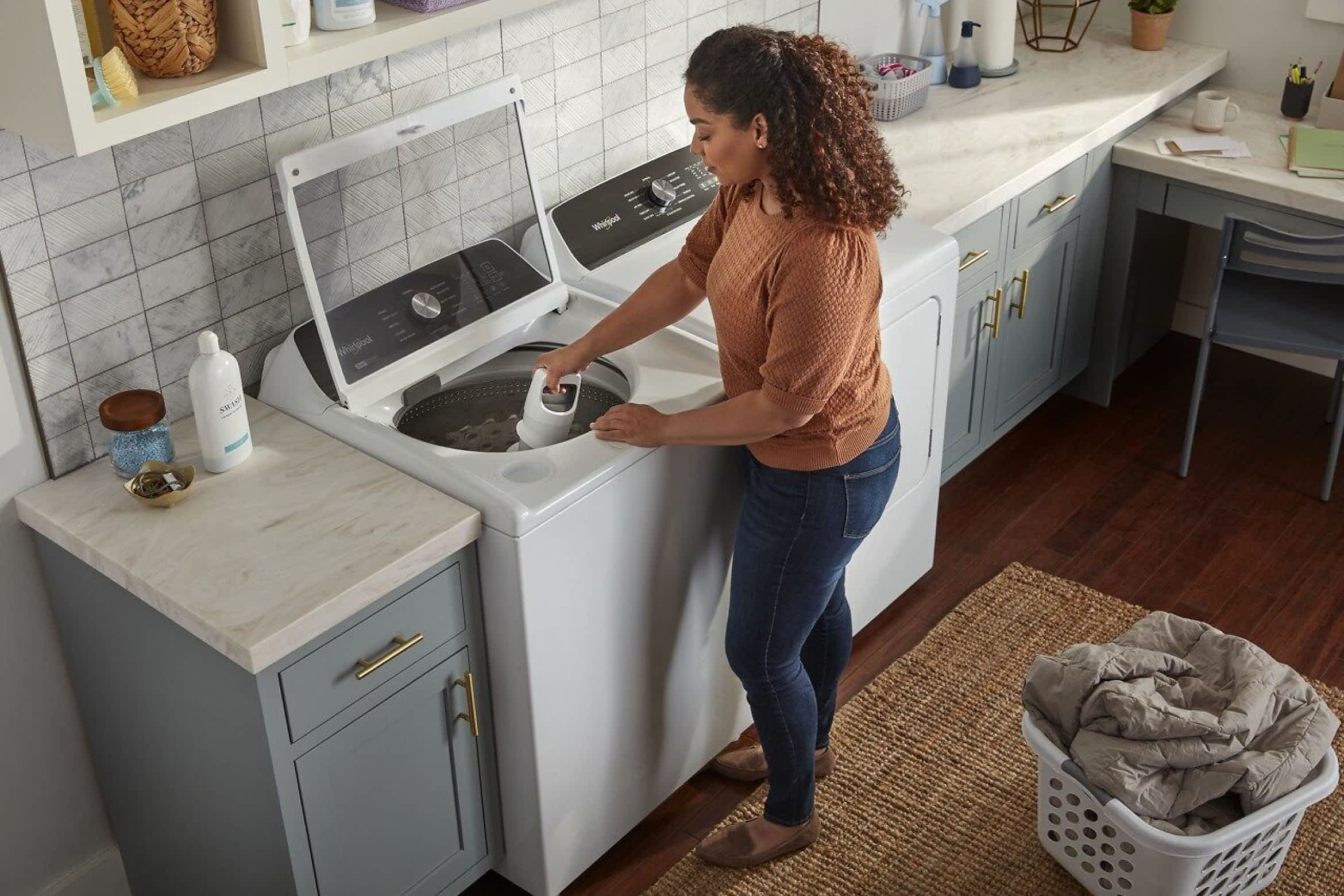 A person removes the agitator from a Whirlpool® 2 in 1 Removable Agitator Top Load Washer
