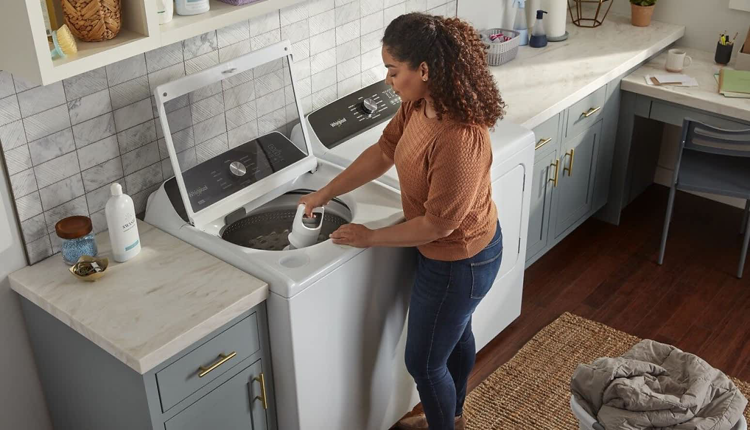 A woman starts a load of clothes in her Whirlpool® Dryer