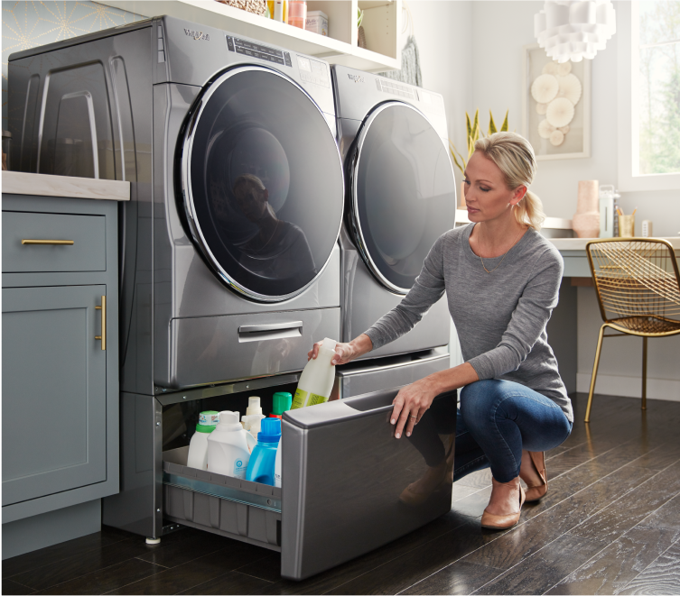 A Whirlpool® Front Load Washer and Dryer side-by-side on top of laundry pedestals