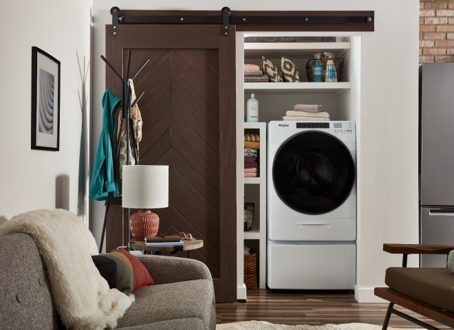 White Whirlpool® All-In-One Washer & Dryer inside of a closet with a sliding barn door
