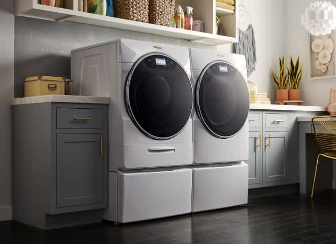 A Whirlpool® Smart Front Load Washer & Dryer Set in a laundry room