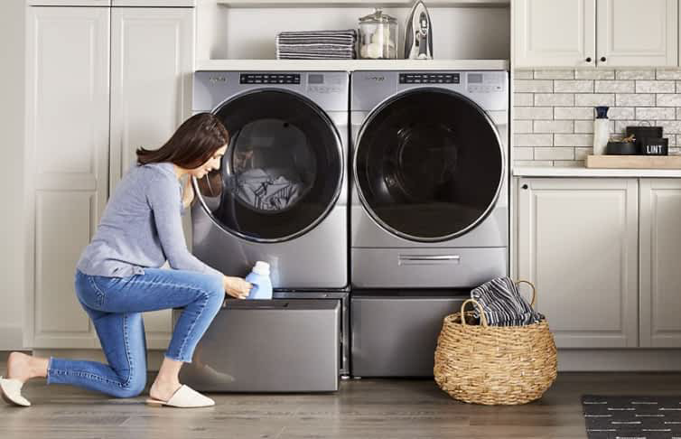 A Whirlpool® Front Load Washer and Dryer set on laundry pedestals