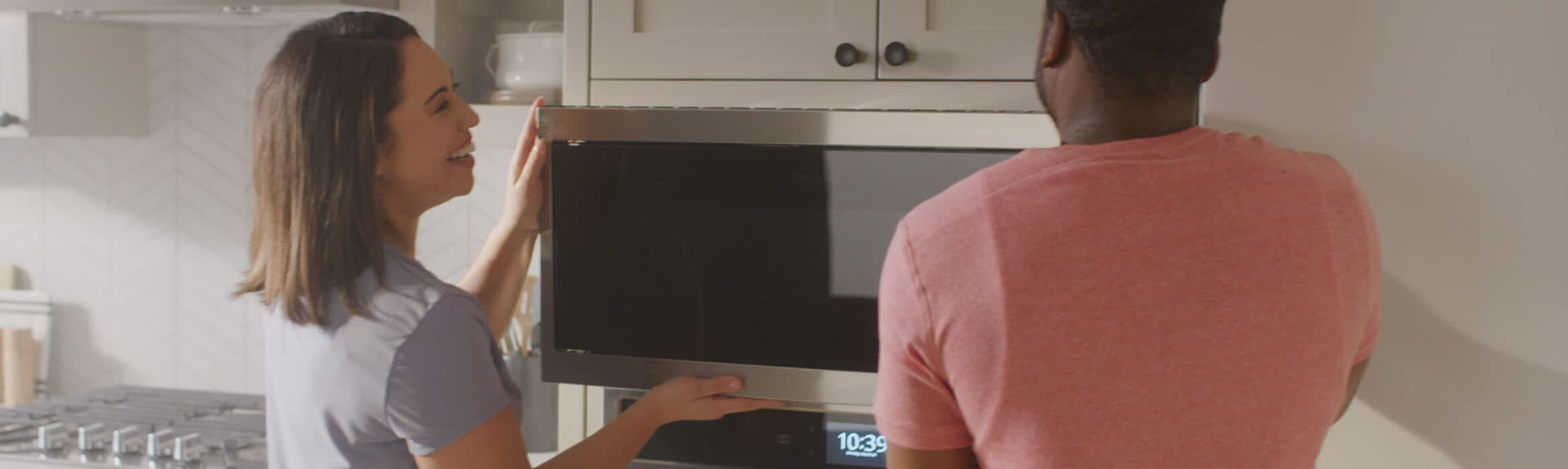A couple installs a Whirlpool® Microwave