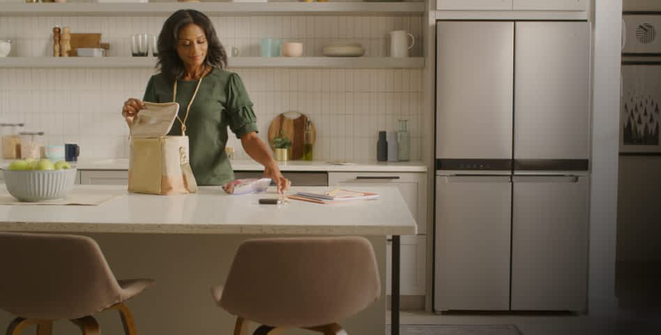 A woman packing lunch in a clean white kitchen