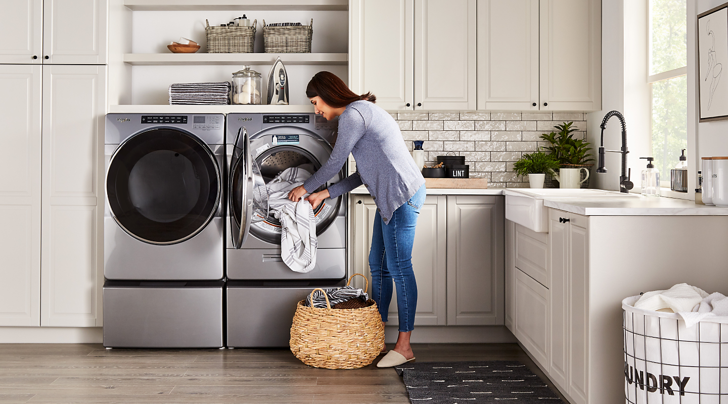 Woman loading laundry in a stainless steel Whirlpool® dryer