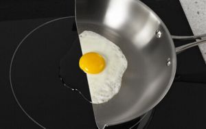 Image de casserole coupée en deux sur une table de cuisson à induction.