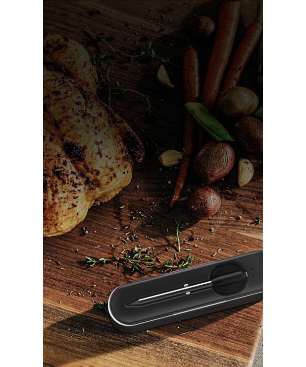 旁边的熟鸡肉和蔬菜Yummly®智能温度计和手机显示应用程序