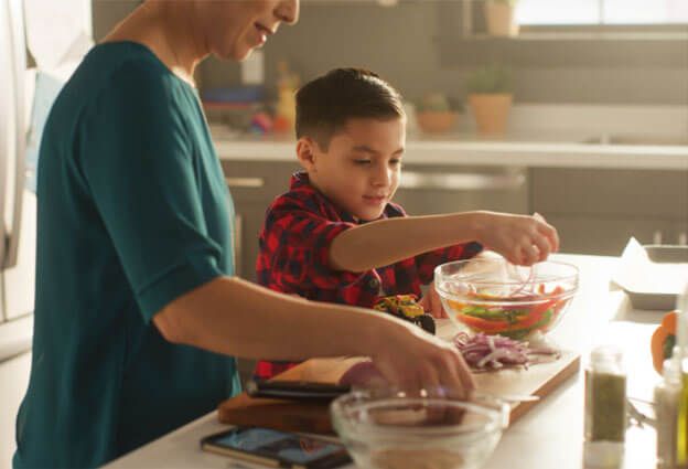 Child helping his mother with dinner