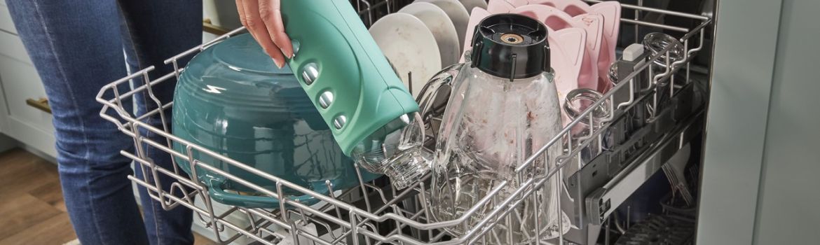 A person loads the top rack of a Whirlpool® Dishwasher