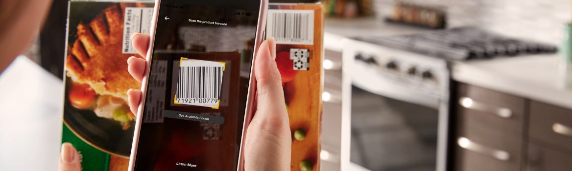 Hands using the Whirlpool® App to scan a barcode.