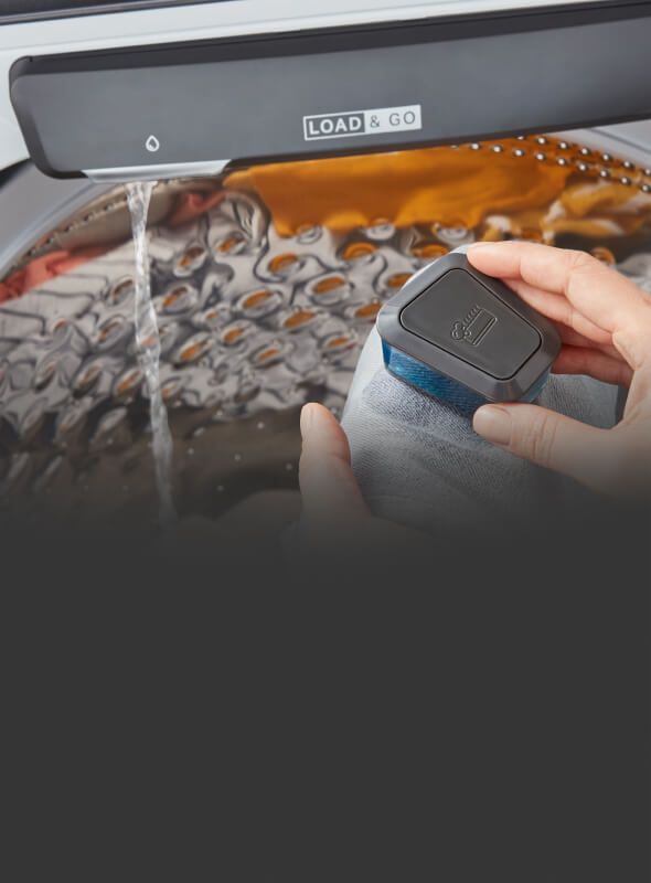 Using the pretreat brush to treat a stain over the washer