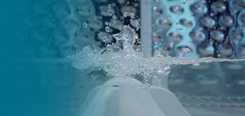 Un bote rojo vaciando detergente liquido en el dispensador Load & Go, de una lavadora Whirlpool con que te permite almacenar detergente y suavizante hasta para 40 cargas.