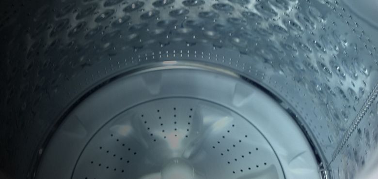 Un bote rojo vaciando detergente liquido en el dispensador Load & Go, de una lavadora Whirlpool con que te permite almacenar detergente y suavizante hasta para 40 cargas.