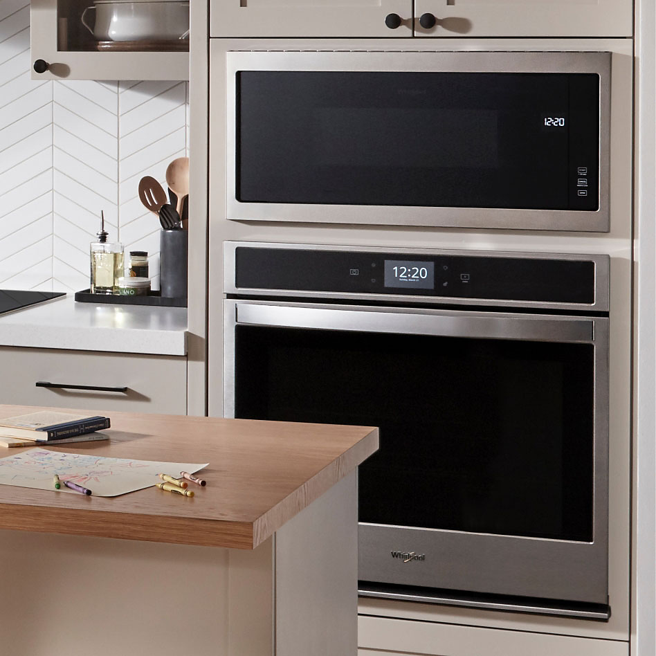 A Whirlpool stainless steel double wall oven built into a kitchen cabinet.