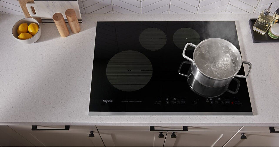 A ceramic hob with a boiling pot of water.