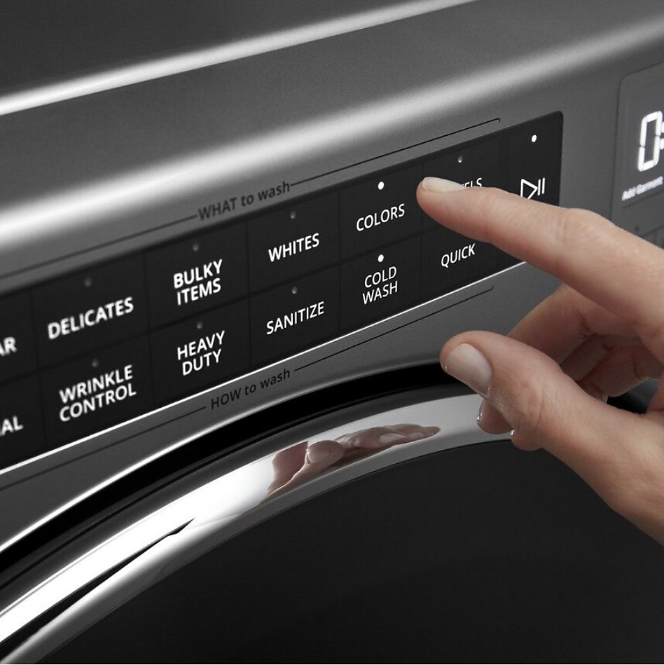 Someone selecting a cycle option on a washing machine.