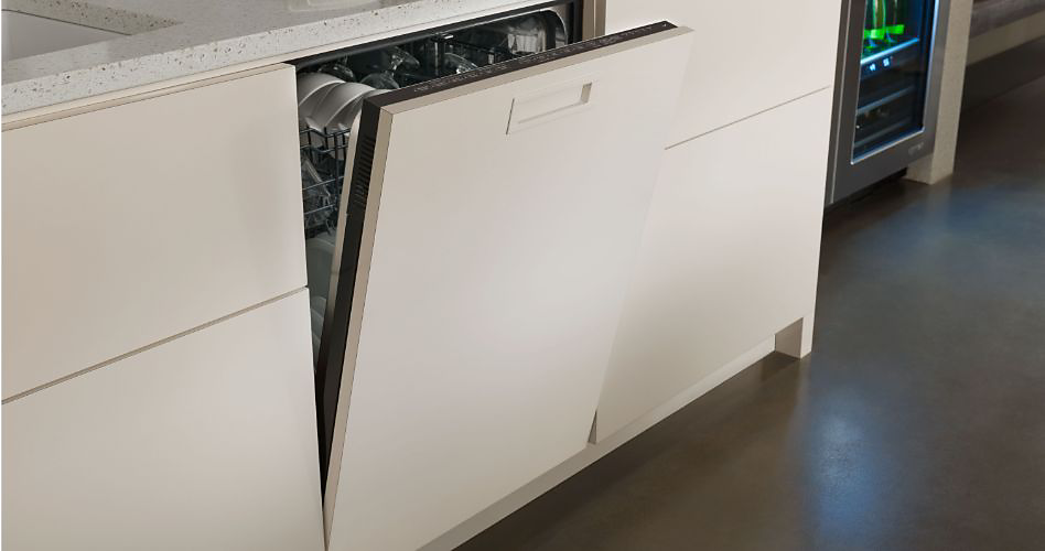 A Whirlpool panel-ready dishwasher with the door ajar. Next to it are two white drawers and in the background is a Whirlpool beverage centre.