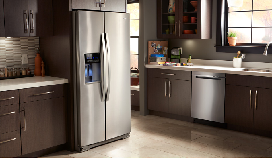 A modern kitchen featuring a Whirlpool stainless steel side-by-side refrigerator and dishwasher