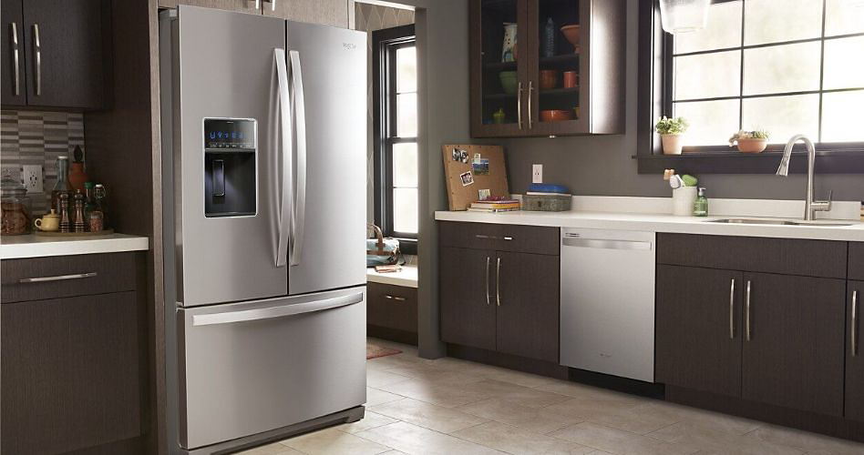A kitchen with a Whirlpool Dishwasher and a Whirlpool Fridge. Several potted plants are on the counter and window sill
