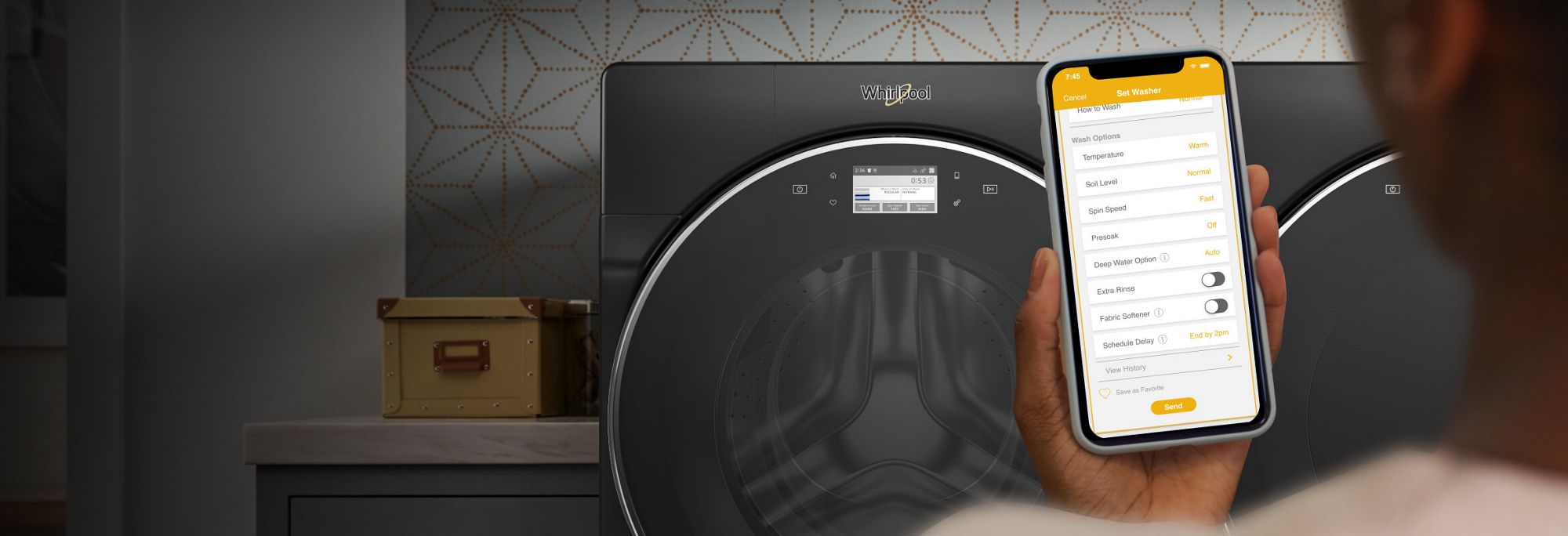 Smartphone with My Home screen in the Whirlpool® app in front of laundry pair