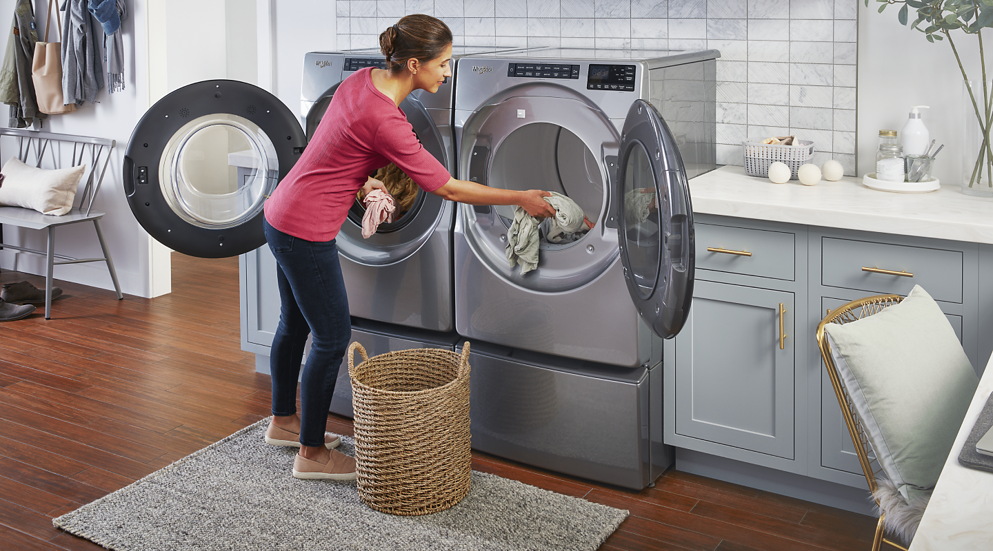 Person loading laundry into a Whirlpool® dryer